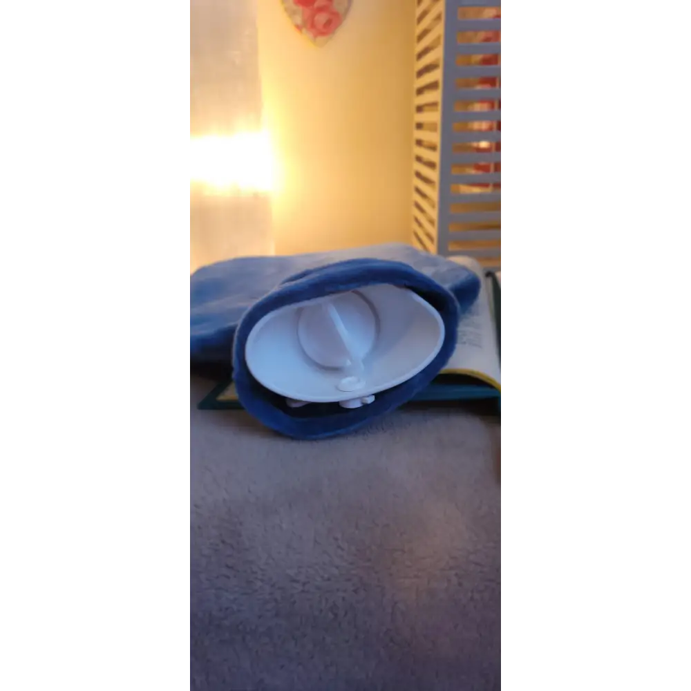 Blue baseball cap on its side beside Fashy Hot Water Bottle with removable cover
